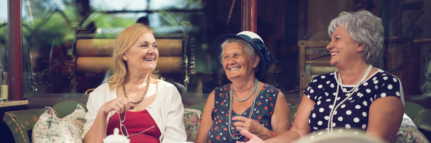 3 elderly friends talking and smiling